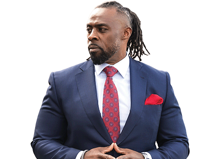 Pierre Campbell of The Leadership Network in a navy suit with red tie, arms folded