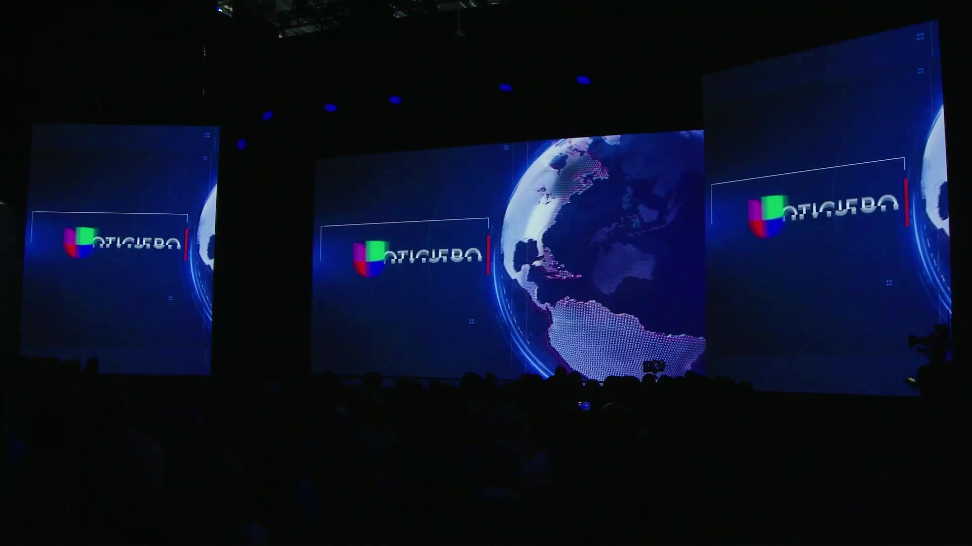 Curved LED stage screens displaying Univision Noticiero — Univision Upfront still
