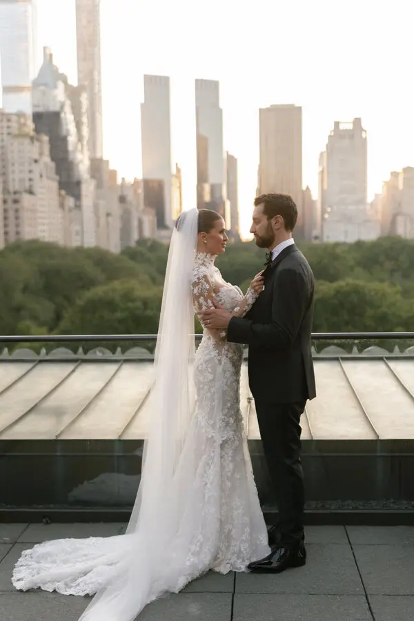 Jessica Markowski and David Weisburd, bride and groom, on a rooftop terrace with the Manhattan and Central Park skyline at golden hour
