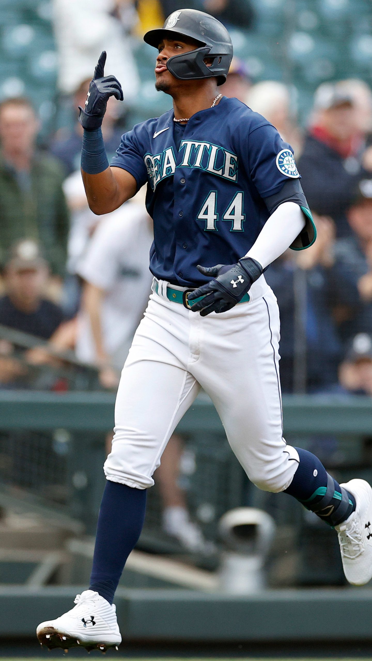 Seattle Mariners player number 44, Julio Rodríguez, celebrating on the field and pointing upward