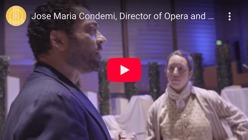 Jose Maria Condemi directing a costumed opera performer in an event venue.