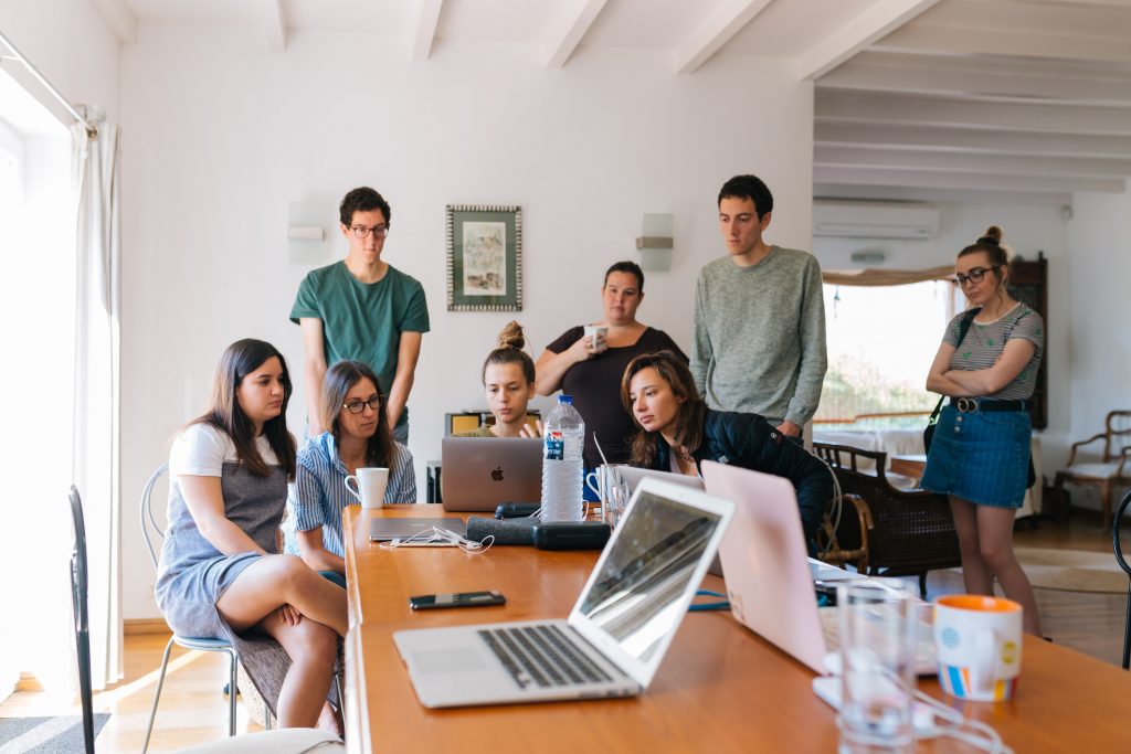 A young team gathered around laptops in a bright office