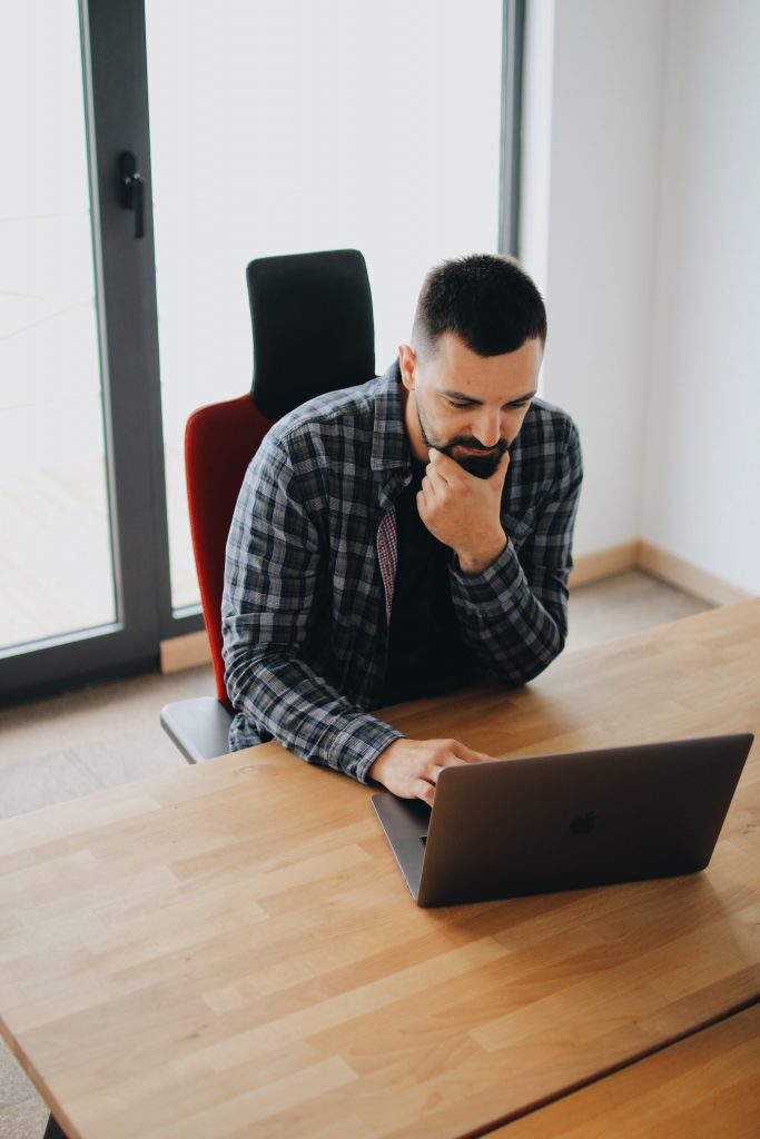 Man working thoughtfully on a laptop