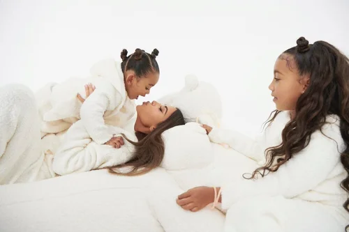 SKIMS Cozy campaign with a woman and two children in white robes