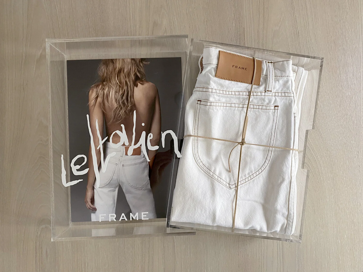 Frame Le Italien gifting package with acrylic box, lookbook card and folded white jeans