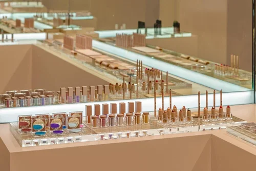 KKW Beauty retail display counters with nude-tone makeup products in rows