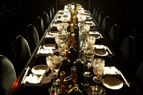 Dark long dinner table with crystal glasses at the François Nars birthday event