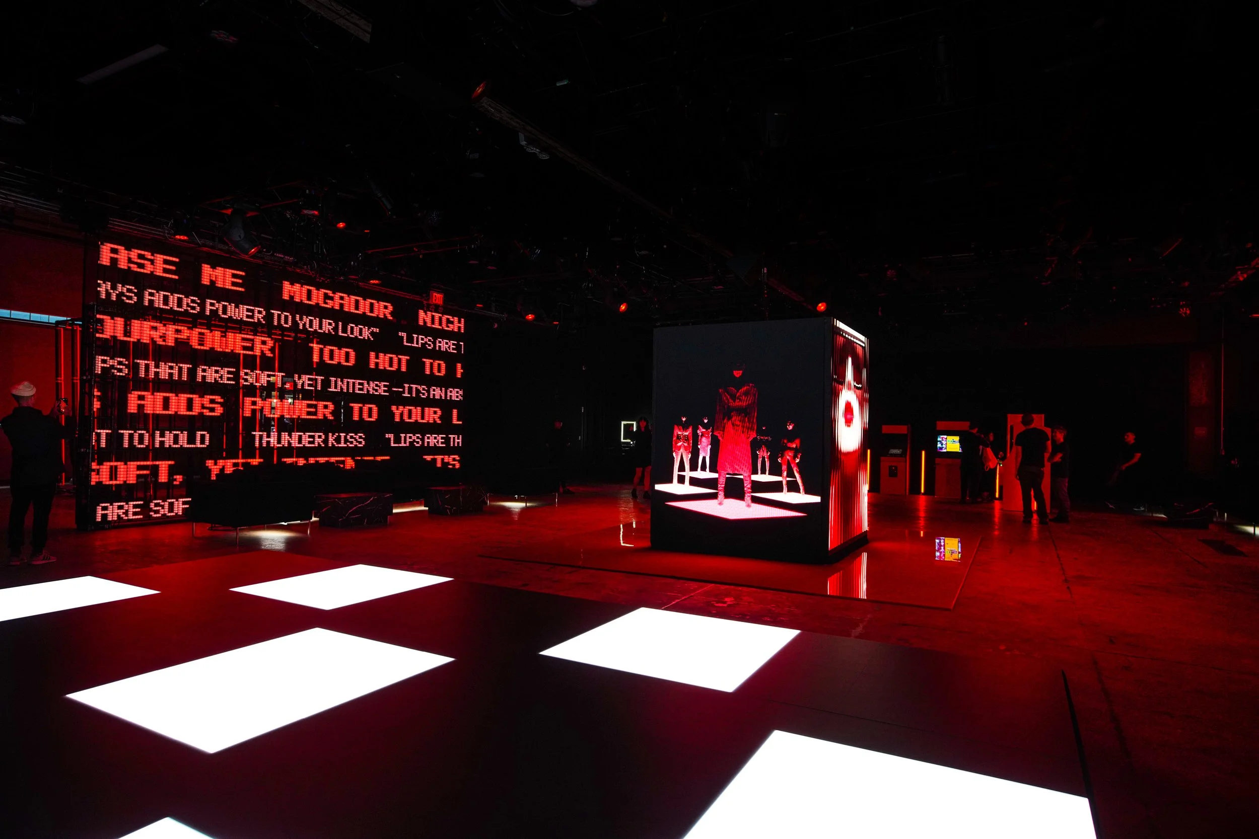 NARS Powermatte launch interior with a large LED text wall and illuminated floor panels in red light