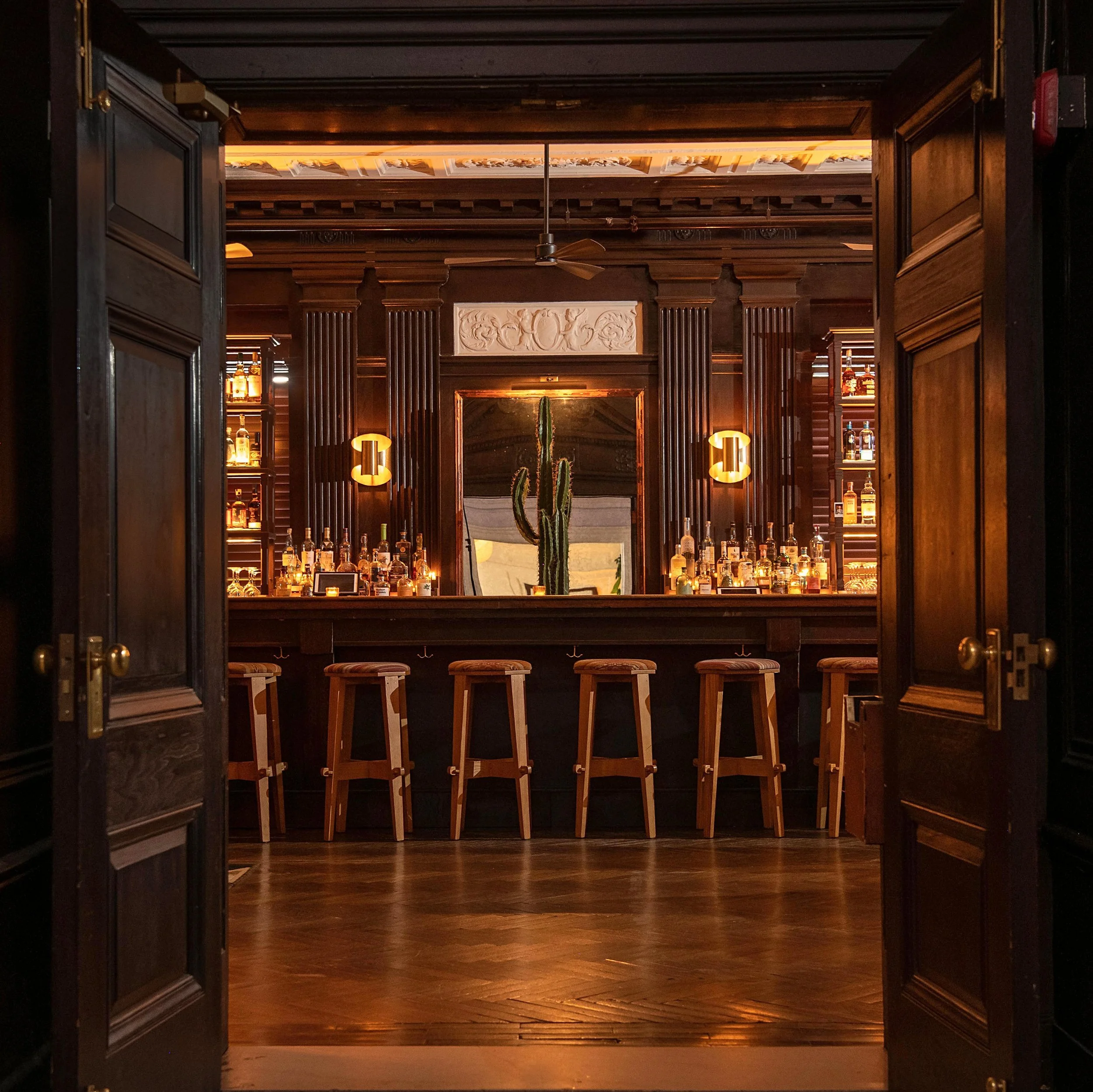 Dimly lit upscale bar interior with bottle-lined shelves