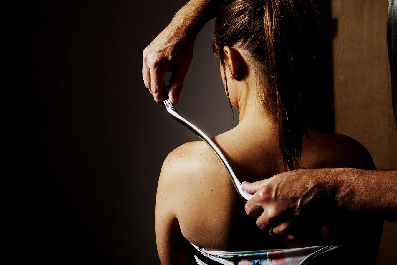 Instrument-assisted soft tissue technique applied to a patient's upper back