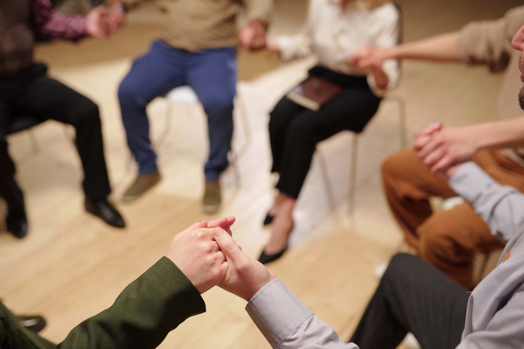 A group holding hands in a circle during a session