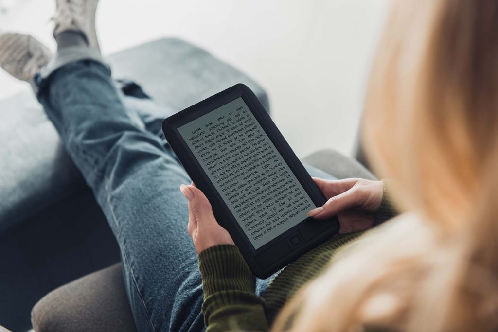 A woman reading on an e-reader at home