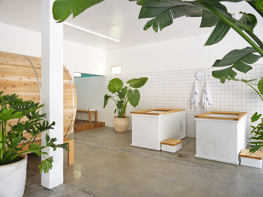 PØLAR — cold plunge tubs and barrel sauna in a bright white-tiled room