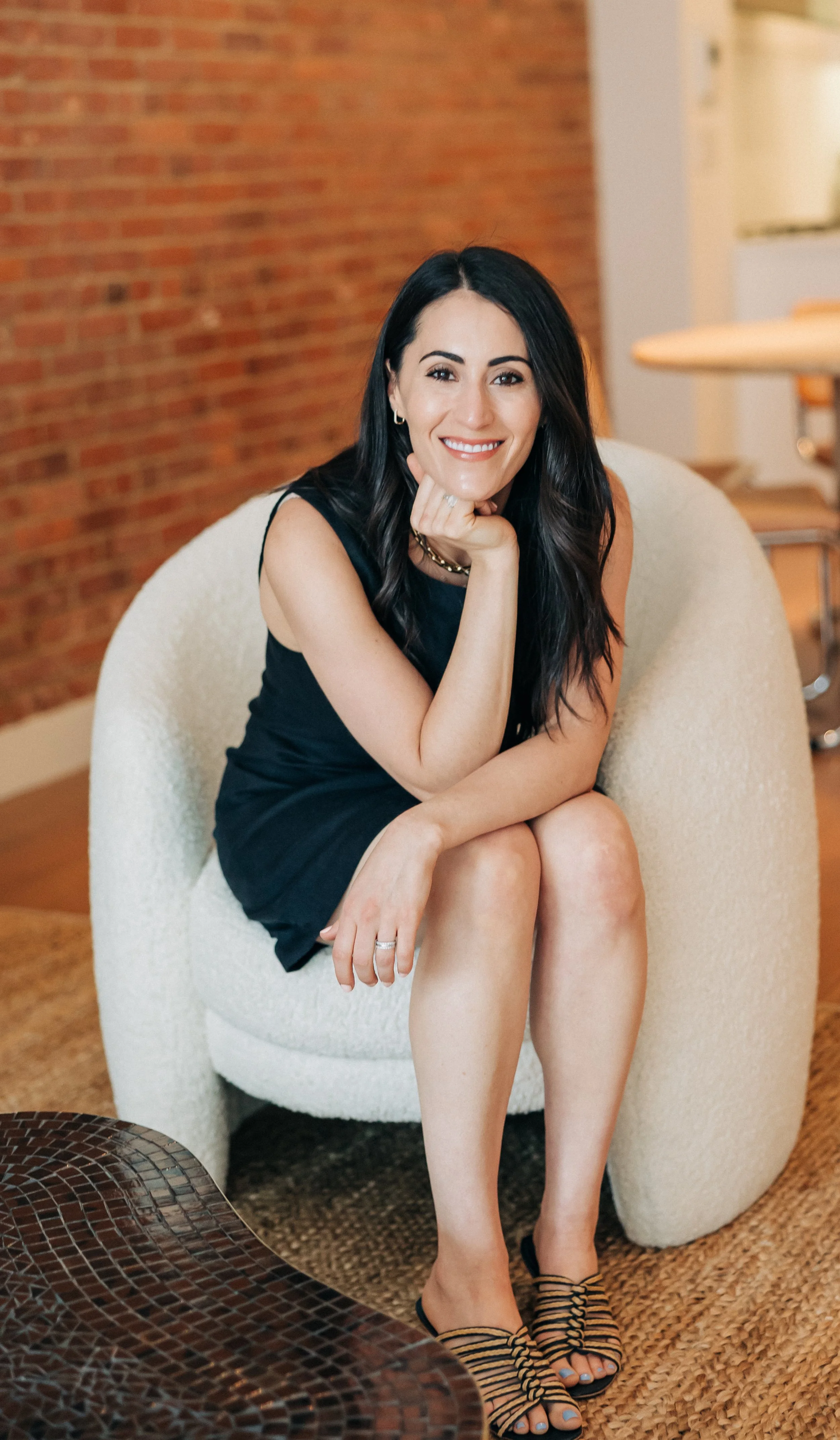 Sarah Rueven, founder of Rooted Wellness, seated in her office