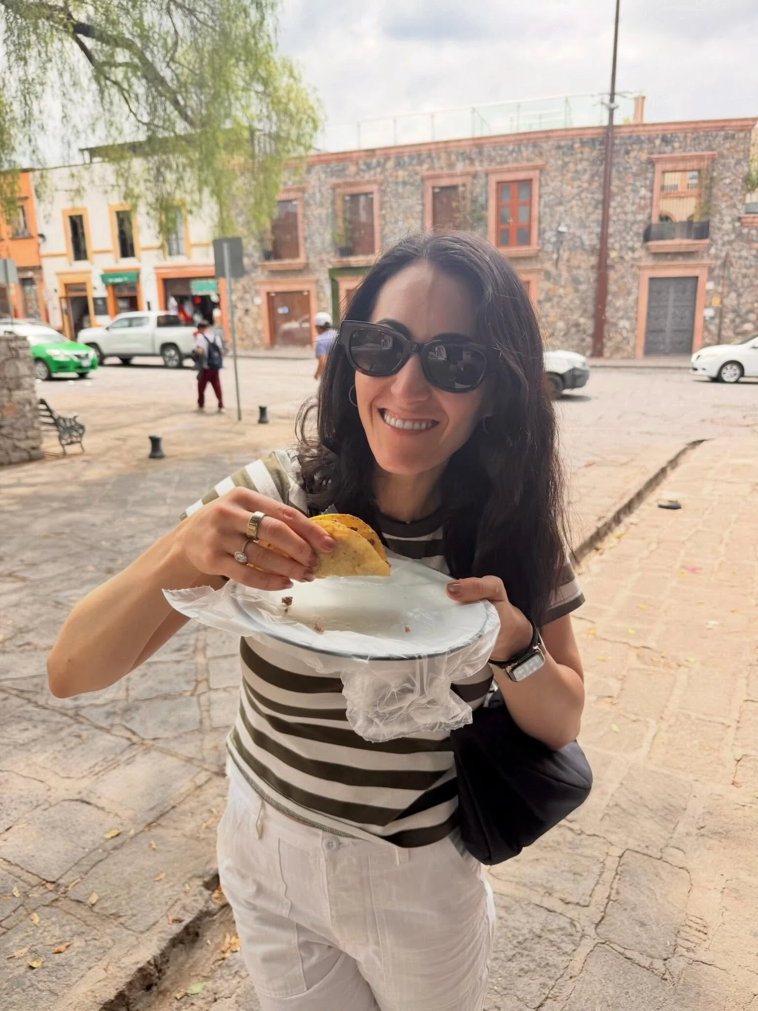 Instagram post: Sarah eating a taco on a cobblestone street — it's starting to taste like summer