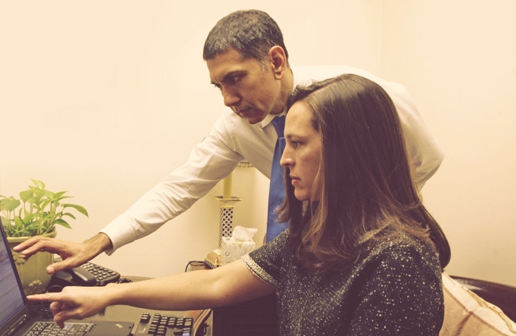 Dr. Samoon Ahmad reviewing results on a screen with a patient in his office