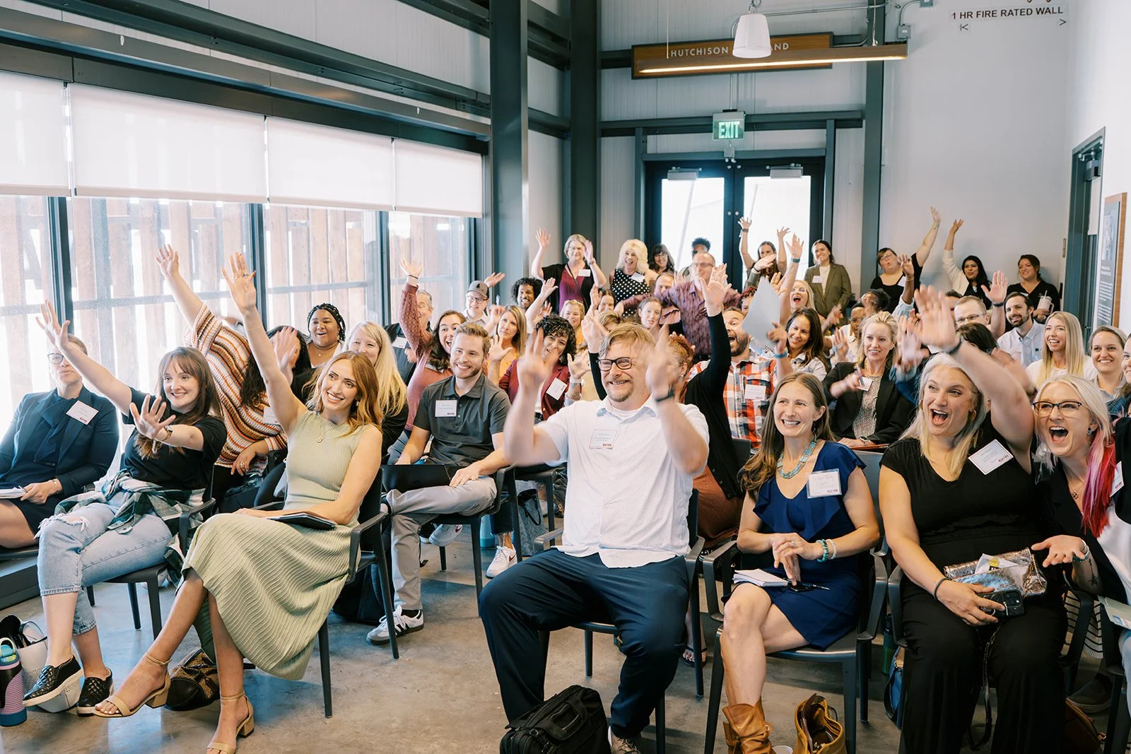 An excited audience raising hands and cheering at the Elevate 2025 conference