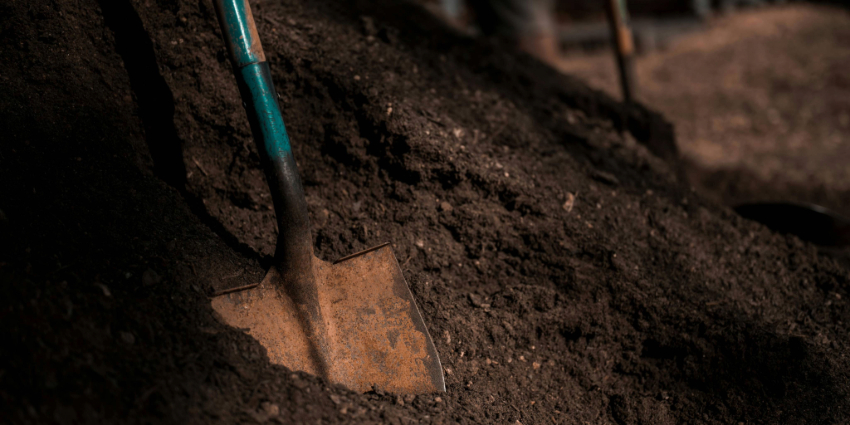 Close-up of a shovel in dark soil