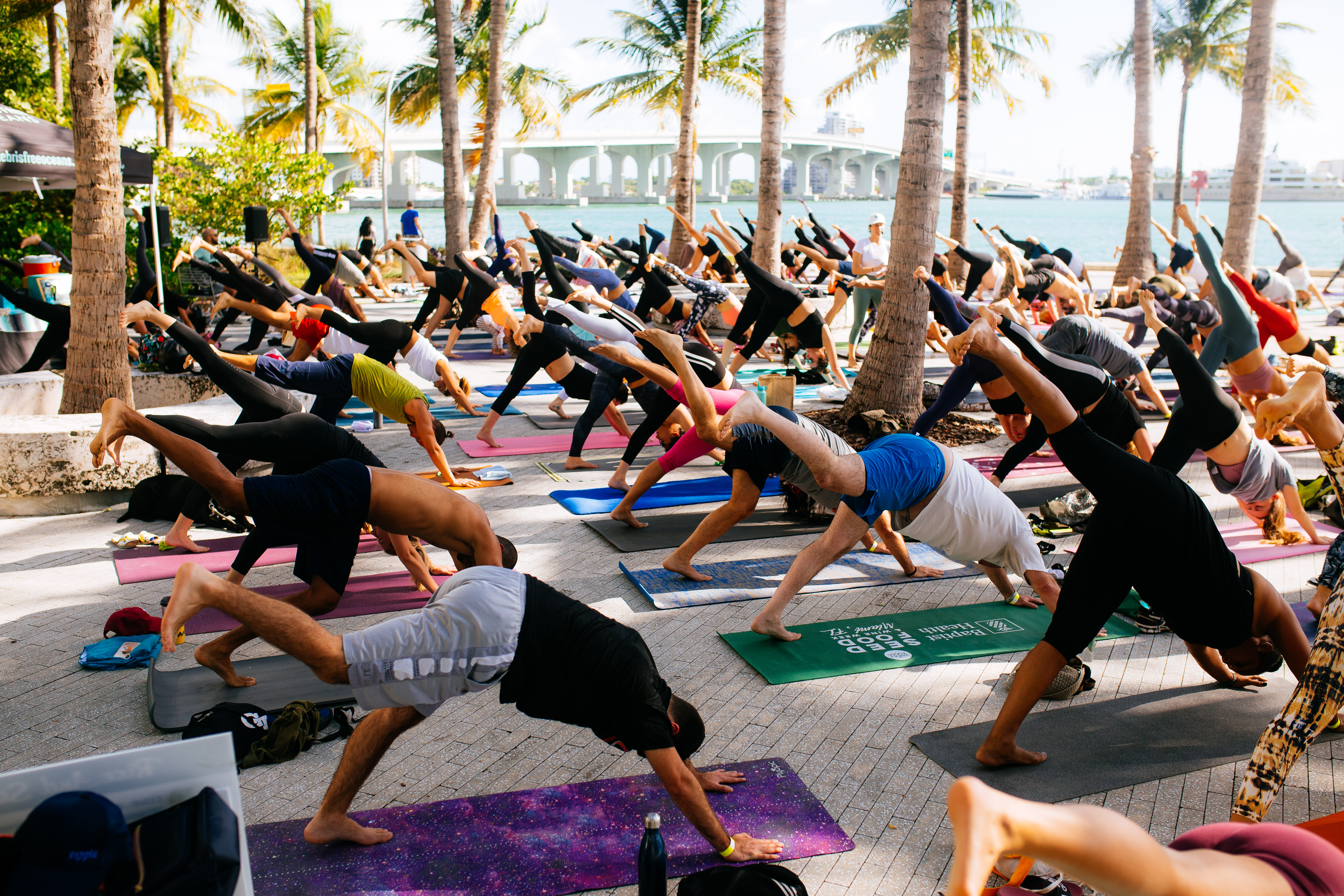 Large outdoor group yoga class on a Miami waterfront plaza