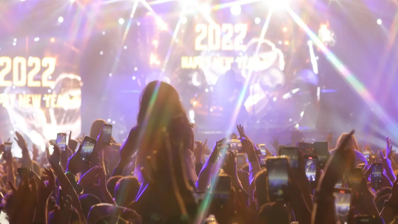Crowd celebrating at Eye Heart NYE 2022 with Happy New Year visuals on stage