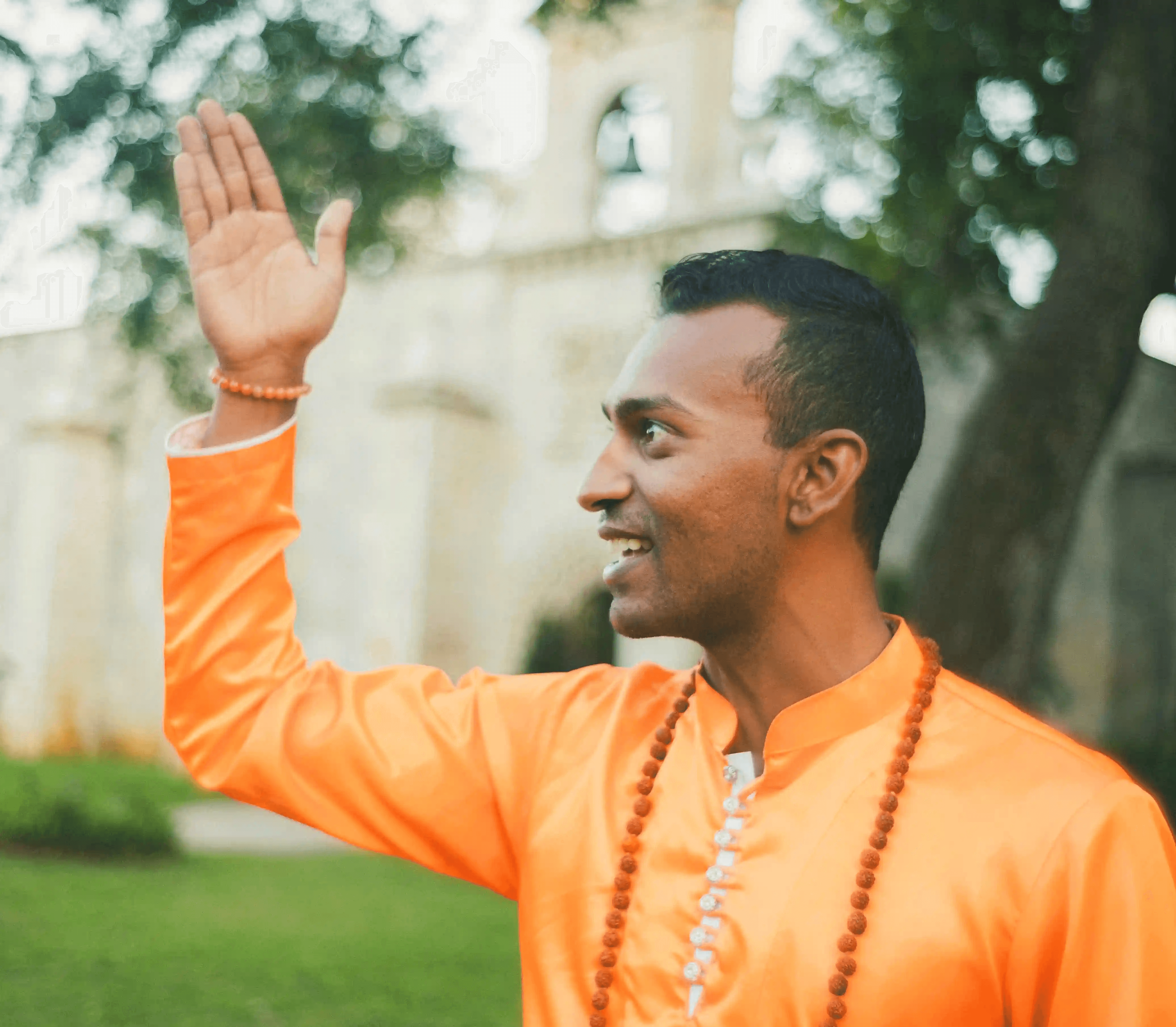 Sri Sudarshan raising his hand in blessing outdoors