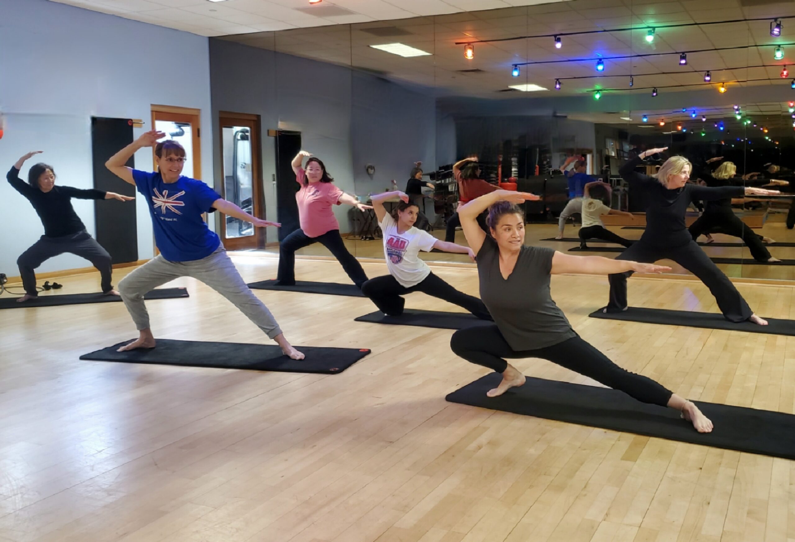 Group qigong and moving-meditation class in a mirrored studio