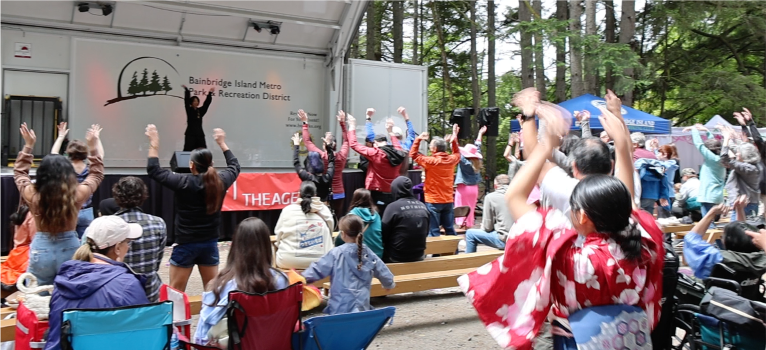 Anna Choi leading a large outdoor wellness event