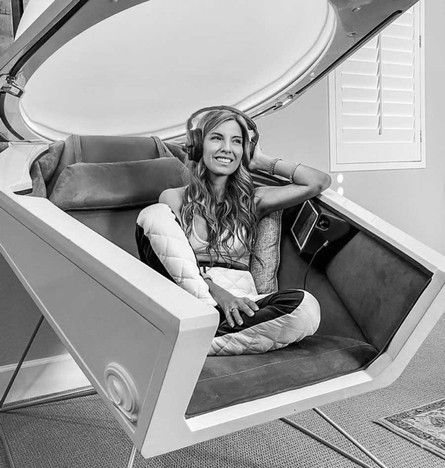 Karla Lui with headphones inside an open Somadome pod