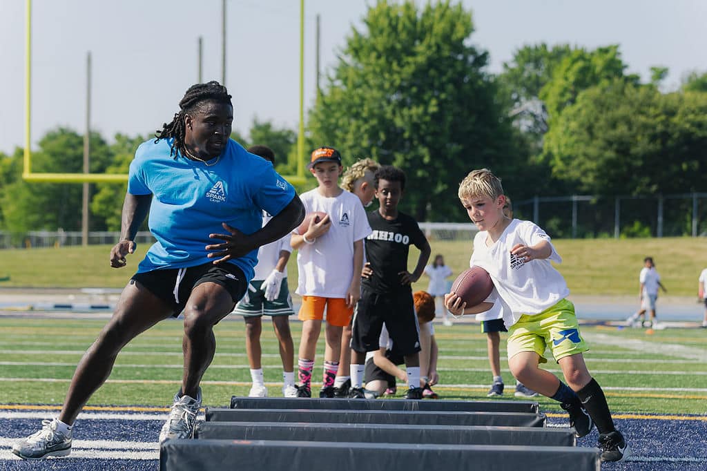 Coach racing alongside a camper carrying a football