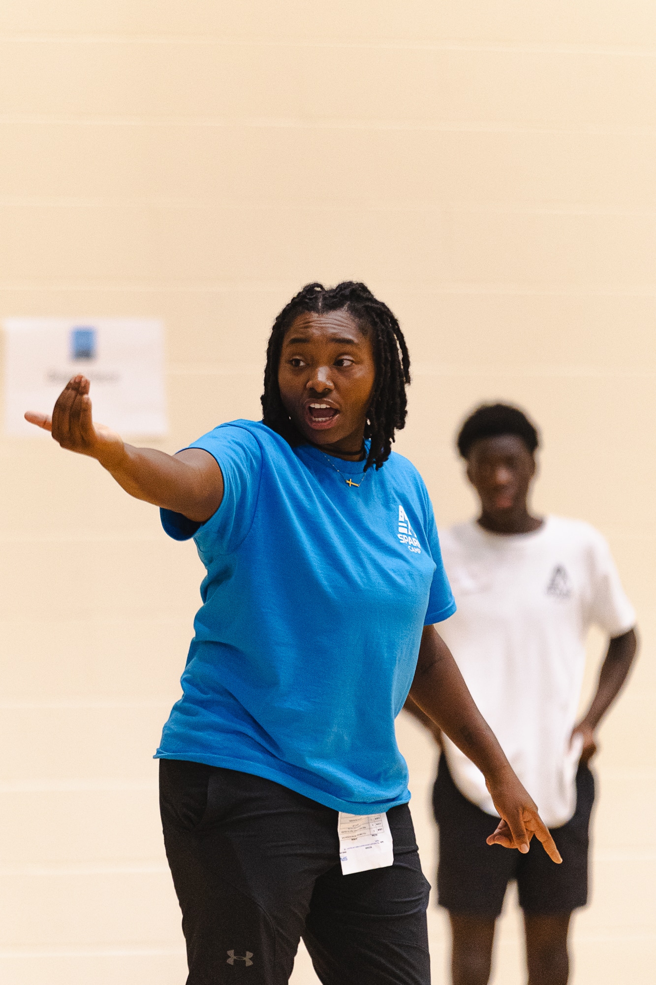 Female Spark Camp coach directing players in a gymnasium