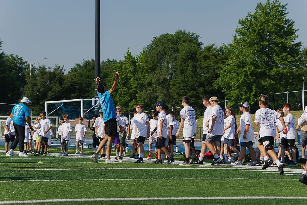 Large group of campers running a drill on the turf field