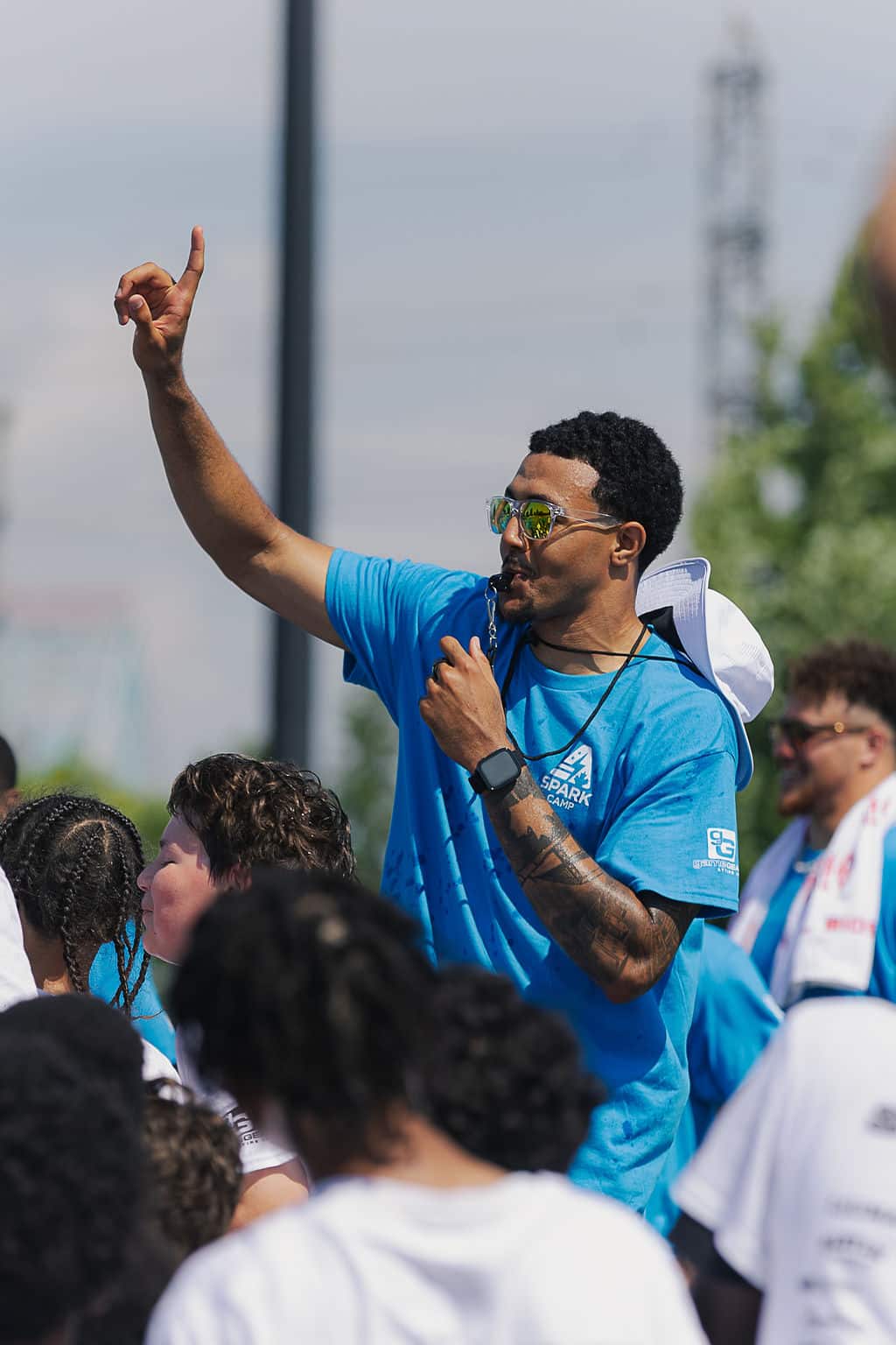 Coach in sunglasses directing an outdoor camp session
