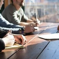 Hands reviewing documents at a table during a consulting session