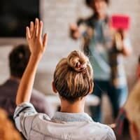 Audience member raising a hand during a speaking session