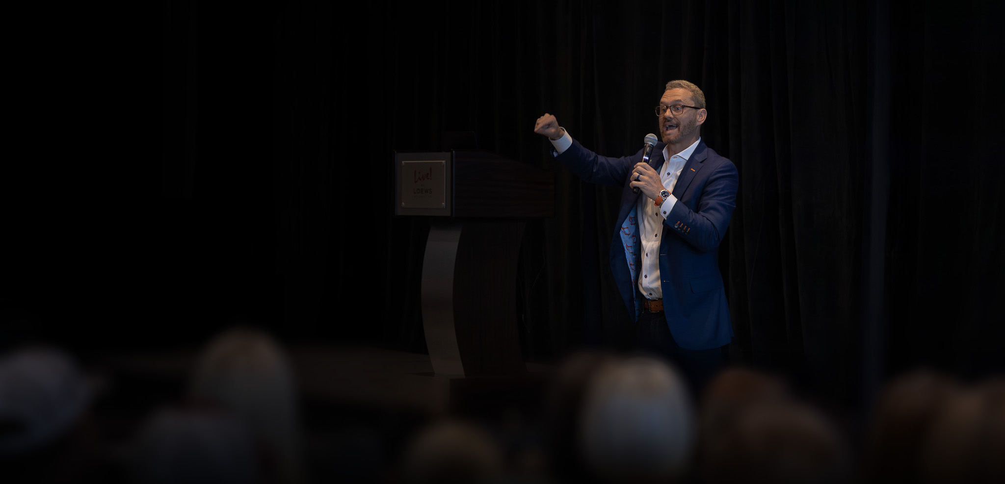 Dr. Zach Schaefer speaking on stage to an audience
