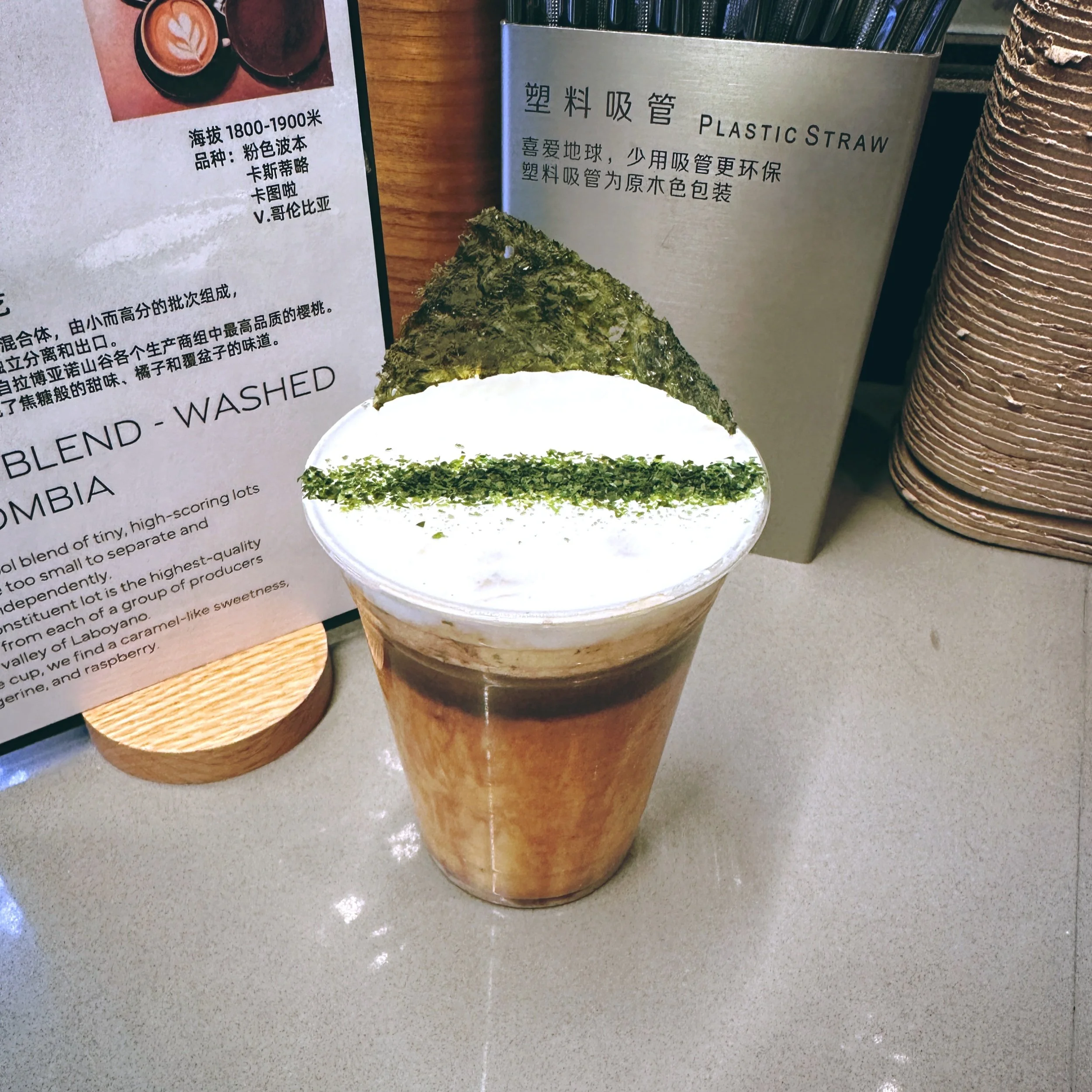 Seaweed Dirty 海苔拿铁 — iced coffee with foam, seaweed flakes and a nori chip in a clear cup