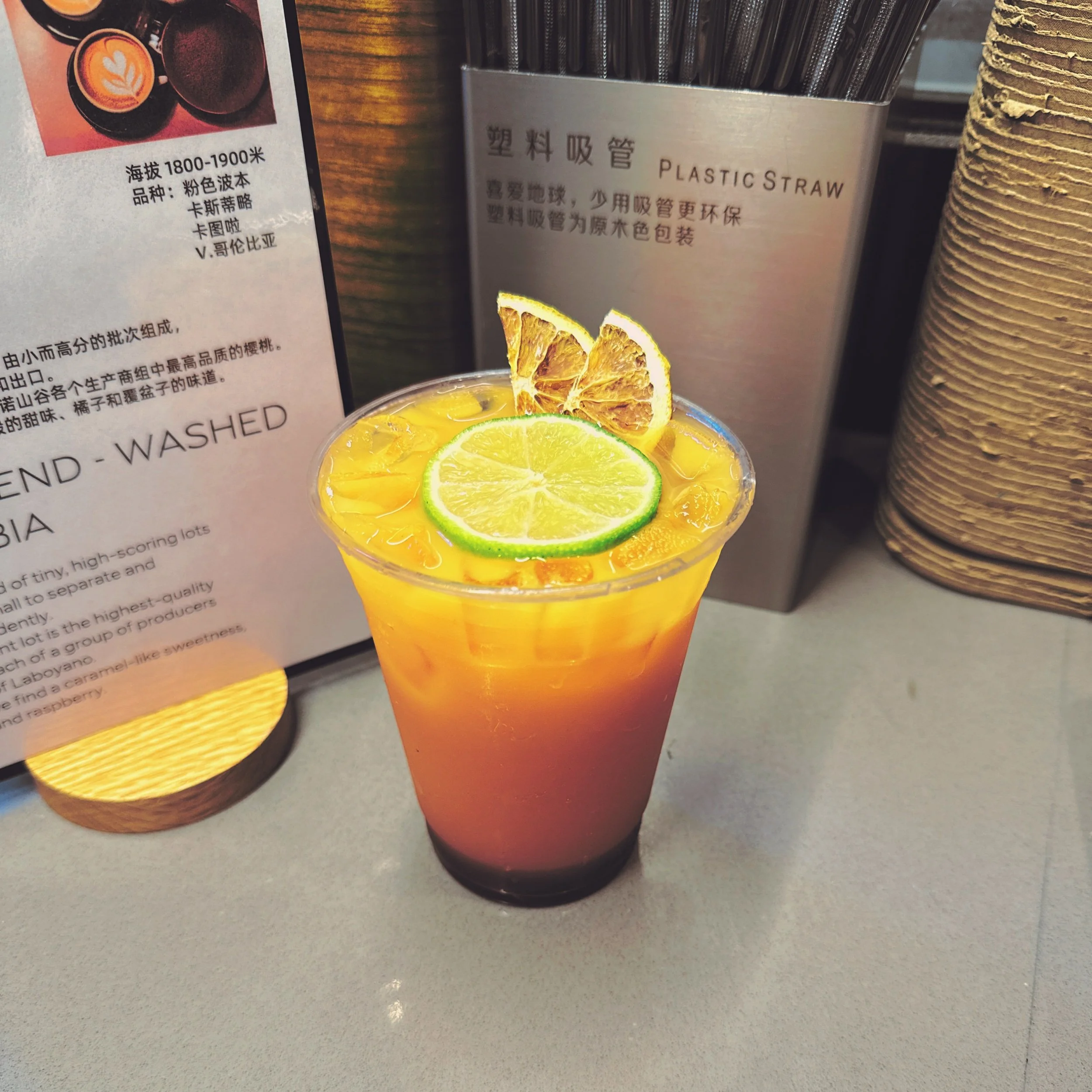 Unknown Tea 知否 — iced citrus coffee with orange and lime slices in a clear cup