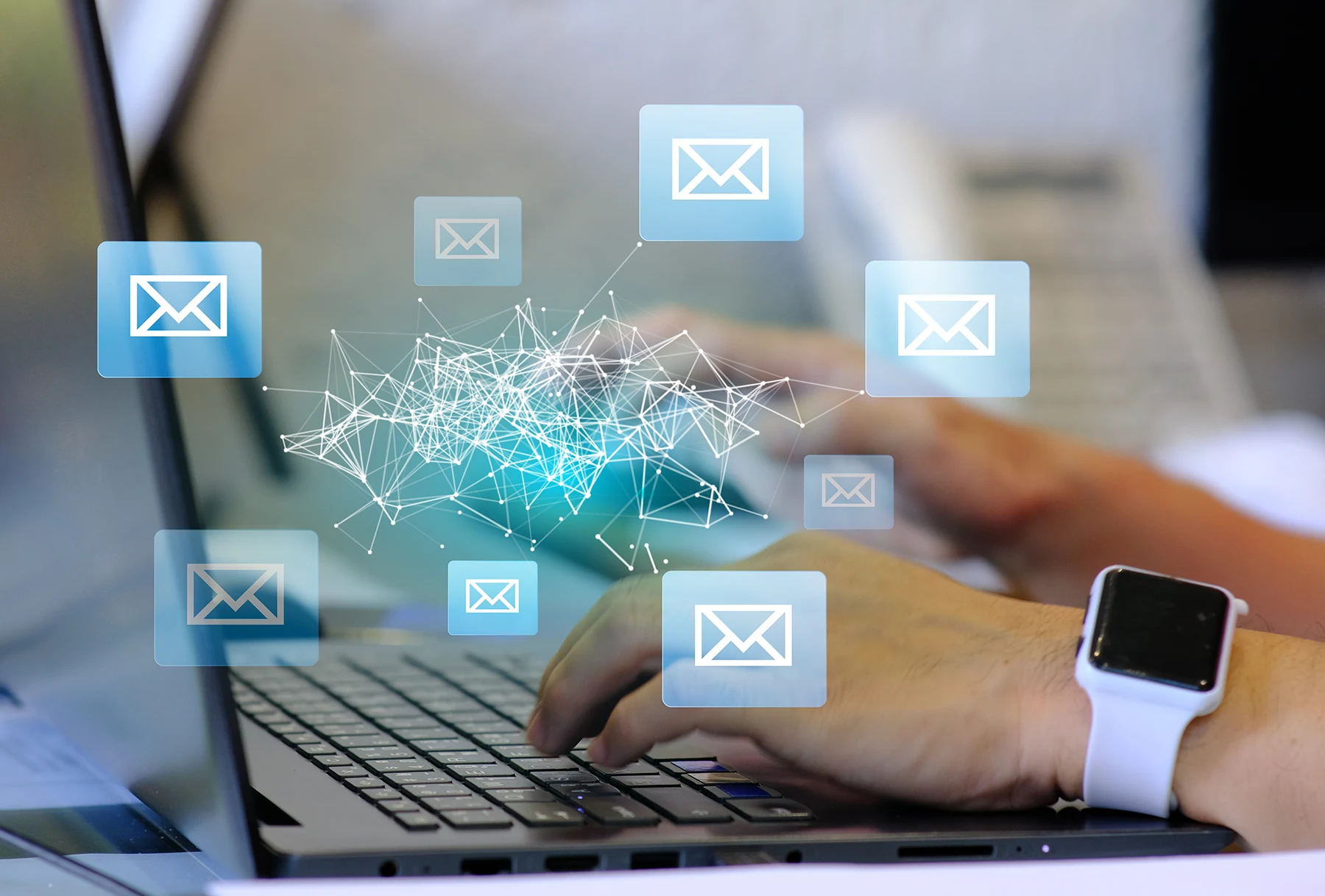 Hands typing on a laptop with email envelope icons overlaid