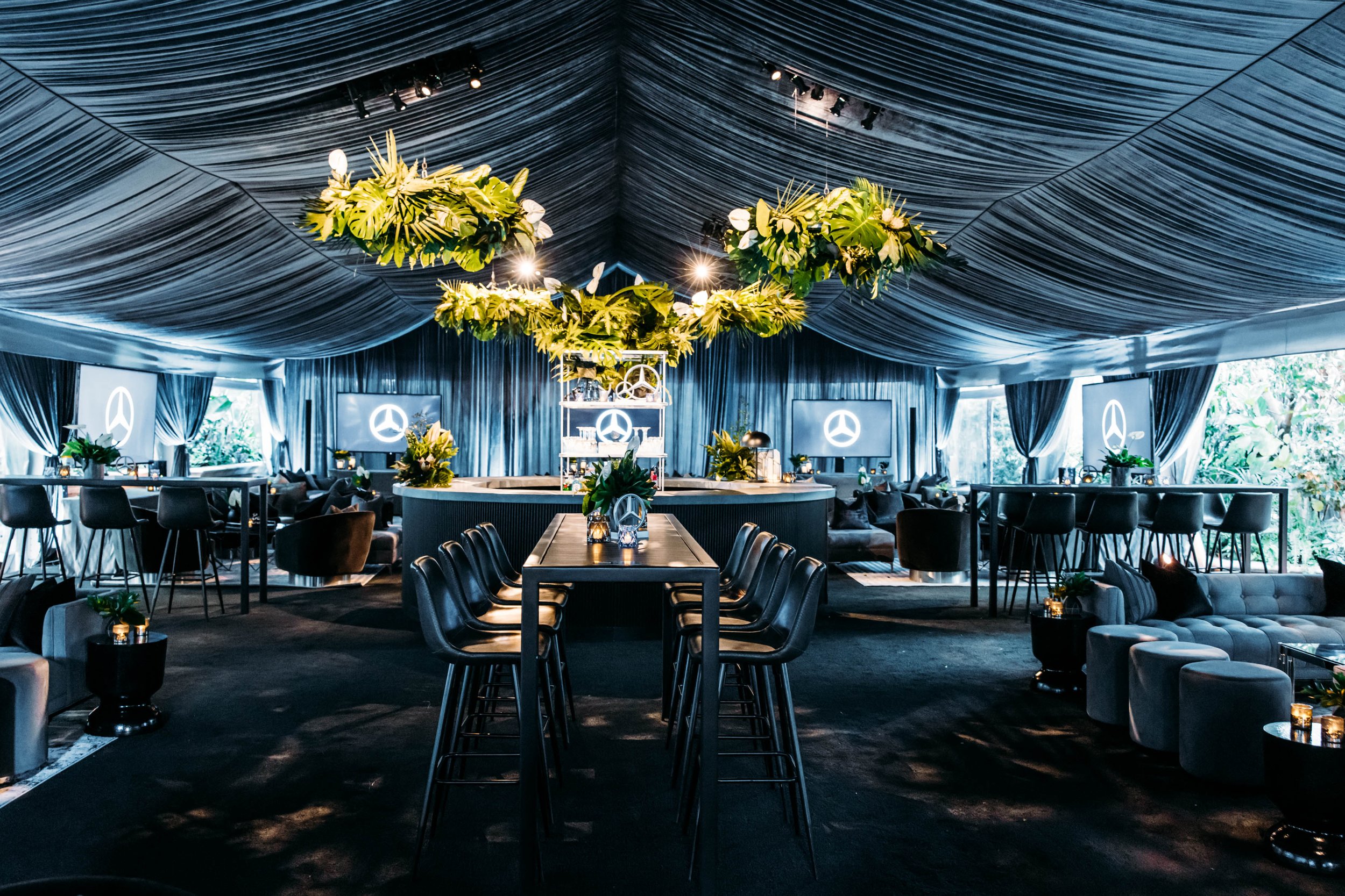 Mercedes-Benz Oscars event interior with draped tent, tropical hanging greenery, circular bar and lounge seating