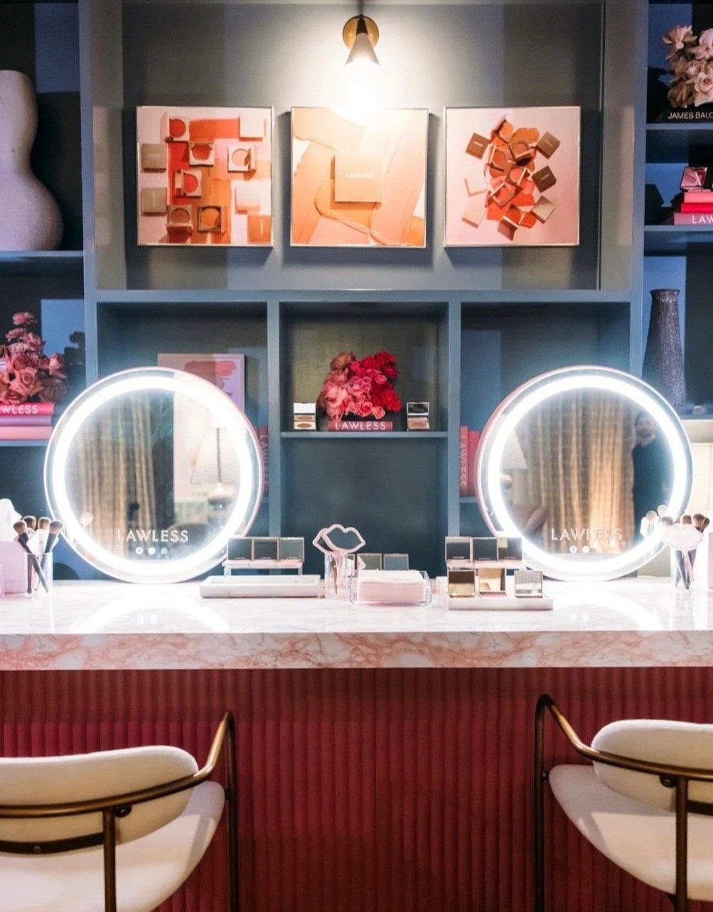 Lawless vanity station with two lit round mirrors and teal product shelving in square Instagram crop