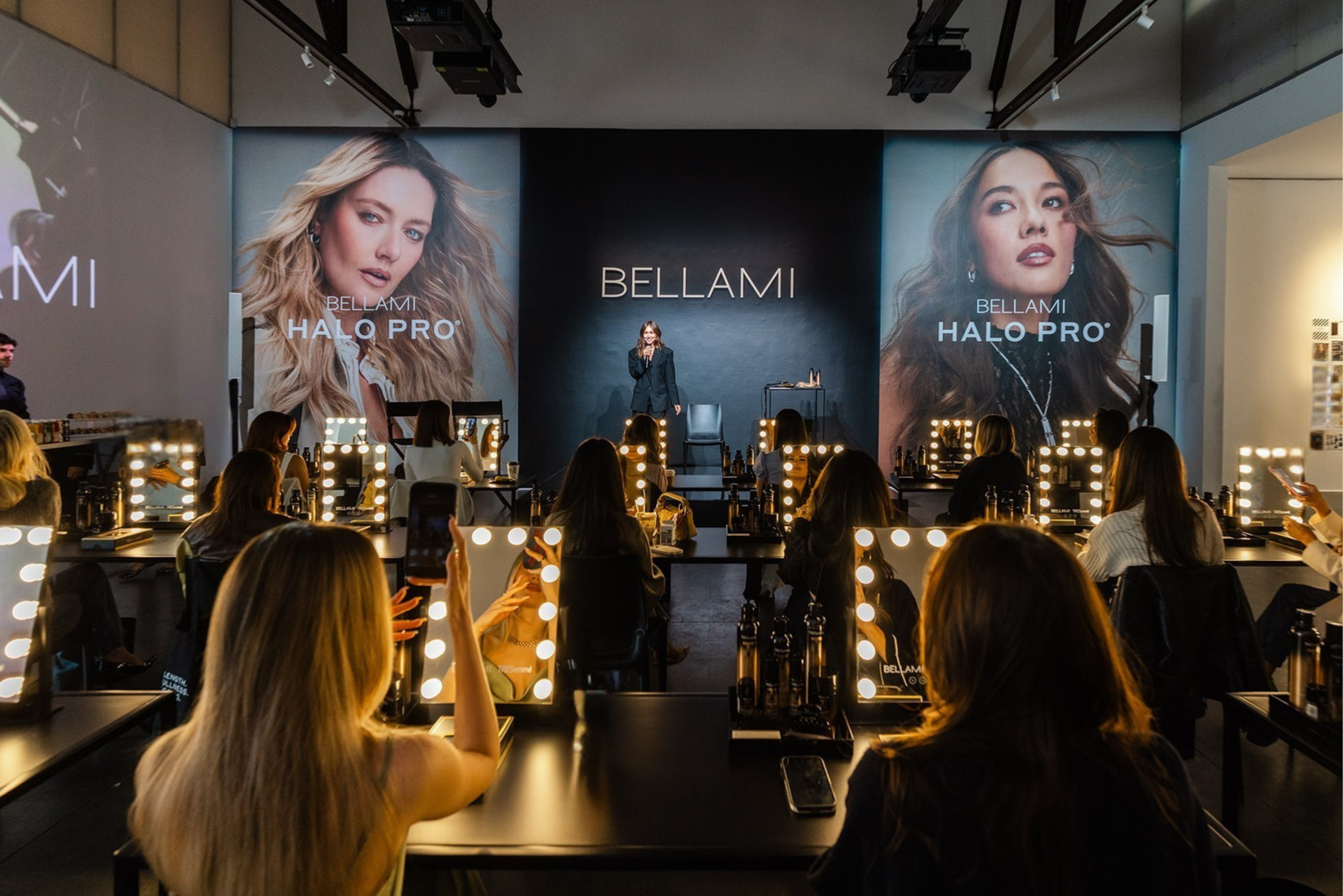 Bellami Halo Pro Masterclass event interior with attendees seated at lit vanity mirrors facing presenter on stage