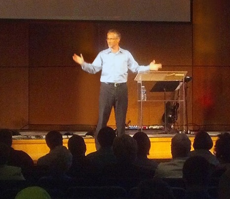 Dr. Brian Wade speaking to a seated audience from the stage
