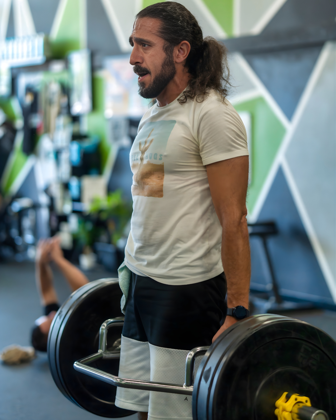 STR11VE member Daniel performing a trap-bar deadlift against the green mural