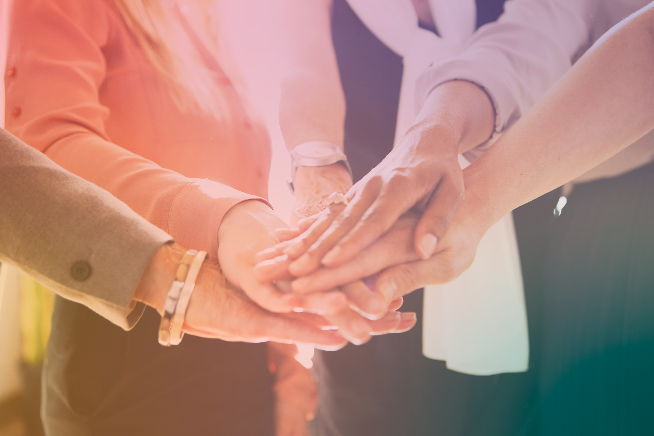 Team members stacking hands together in a huddle