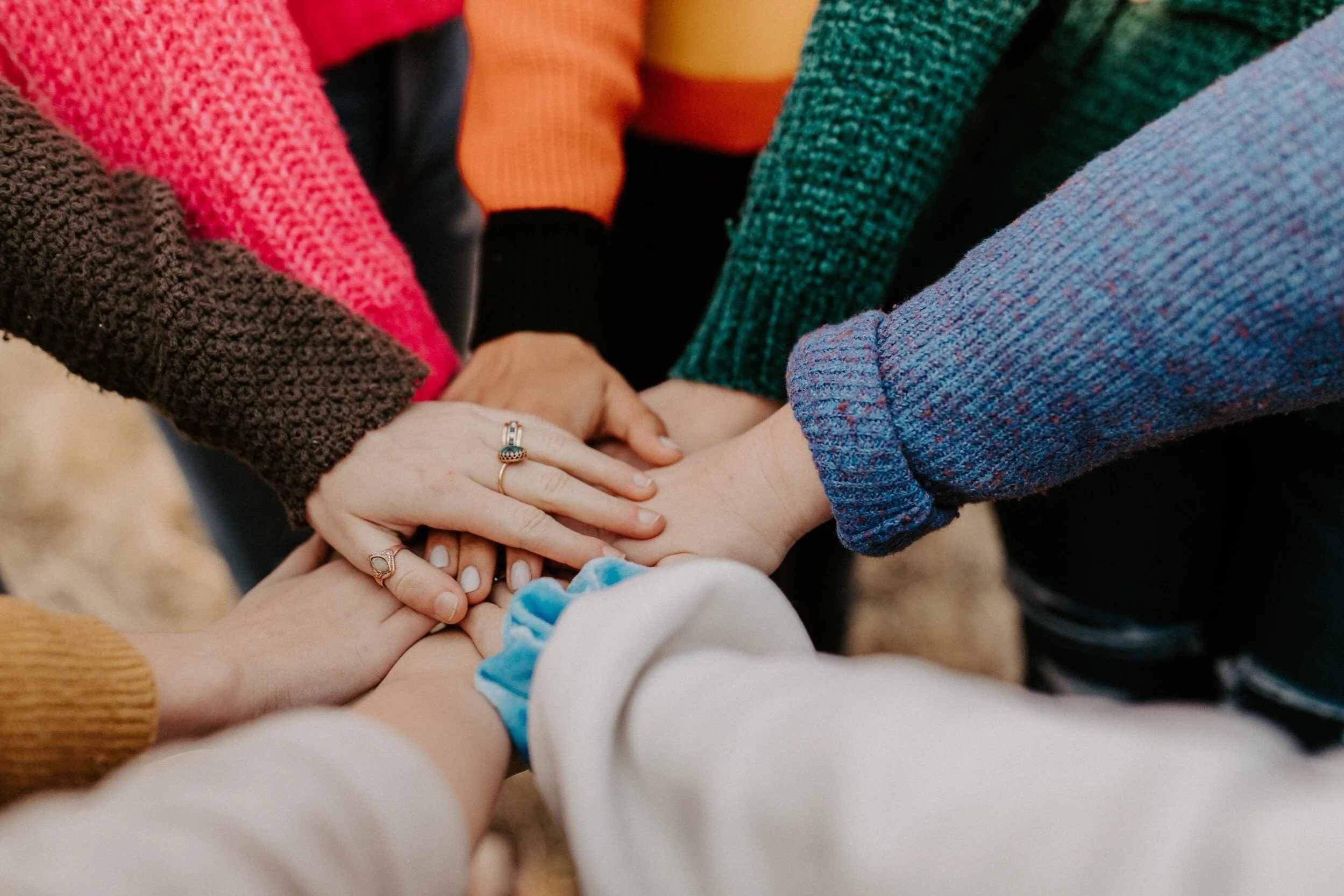 Team members stacking their hands together in a huddle