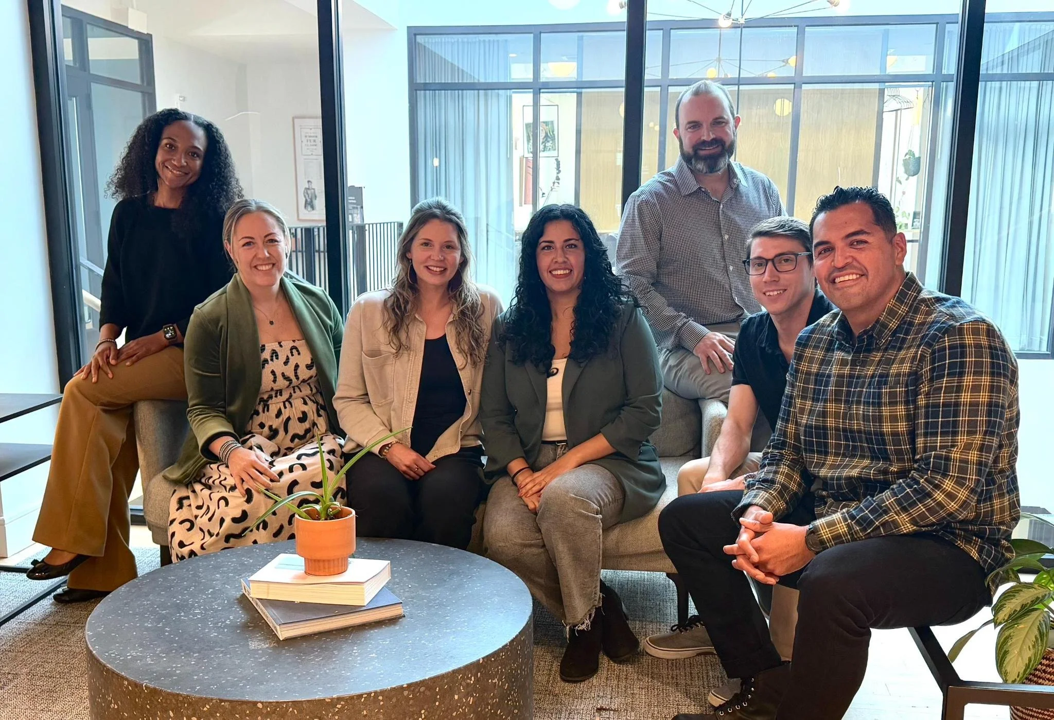 The Surrender Network team of seven professionals together in a bright modern office lounge