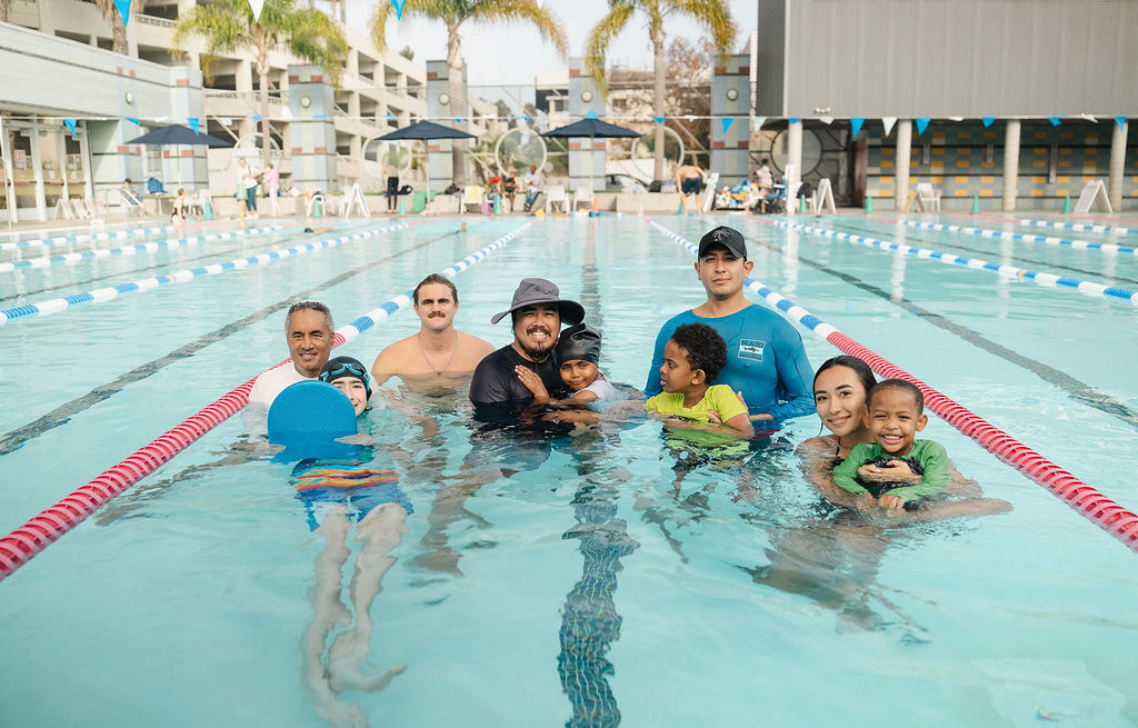 Group photo of SwimSCAAPE instructors and child students together in an outdoor lap pool