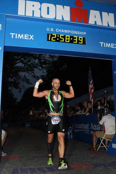 Dr. David Kulla celebrating with arms raised at the finish line of the Ironman U.S. Championship