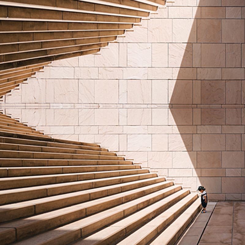 A grand staircase with a small child standing at its base