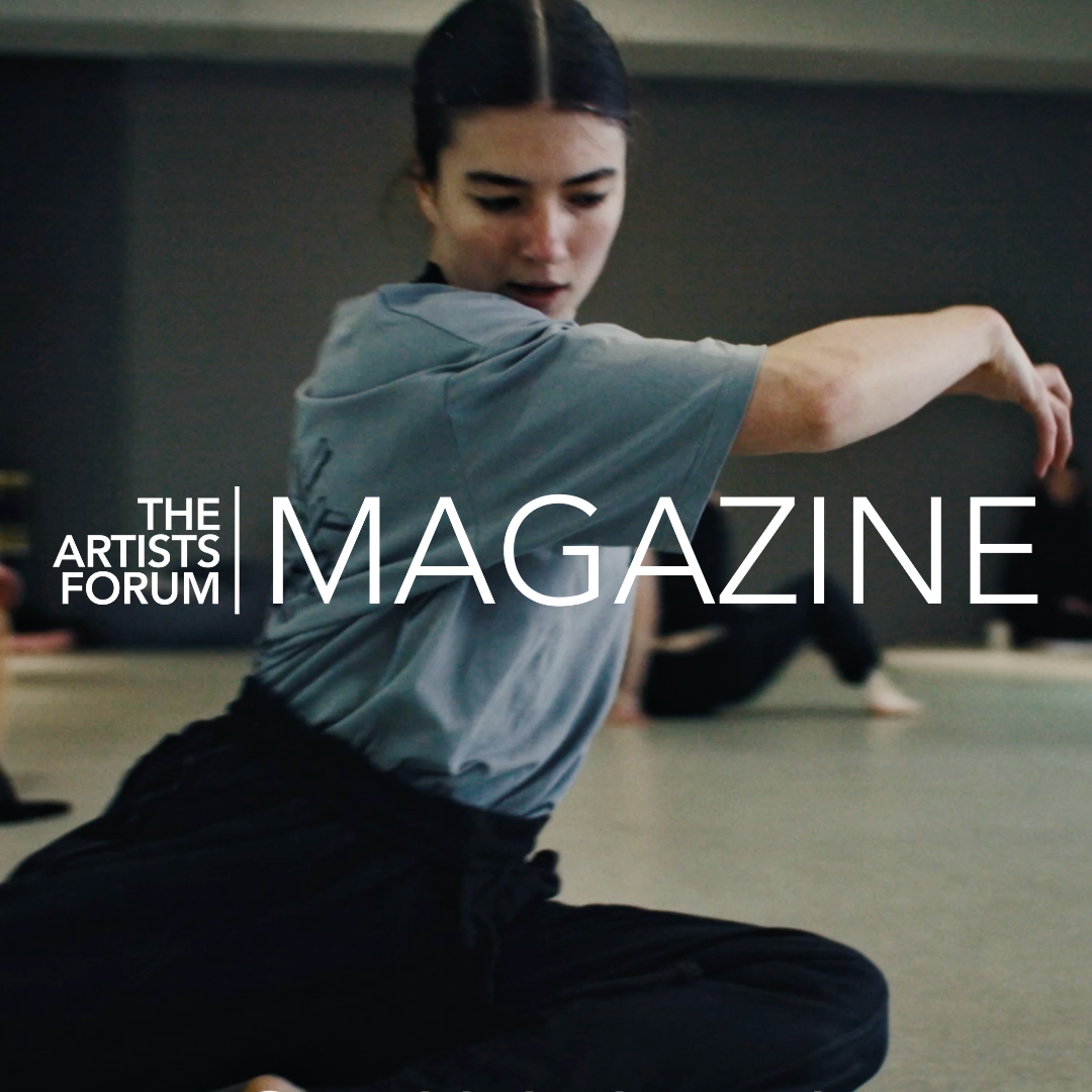Female dancer kneeling on a studio floor mid-movement